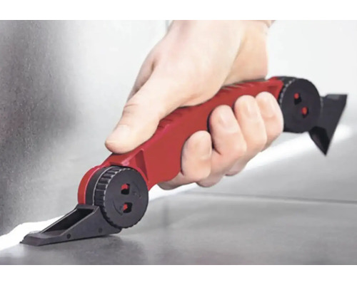 Ruka s červeným škárovacím nástrojom nanášajúca tmel