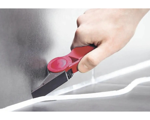 Ruka používa nástroj na odstraňovanie škár na odstránenie škáry.