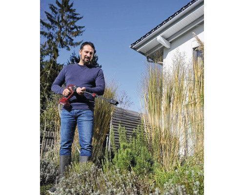 Muž používa akumulátorový tlakový čistič v záhrade.