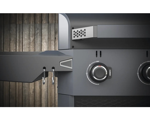 Detail plynového grilu s ovládacími gombíkmi a odkladacou plochou