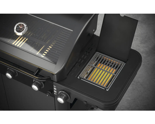 Detailný pohľad na čierny plynový gril s bočným horákom a ukazovateľom teploty.