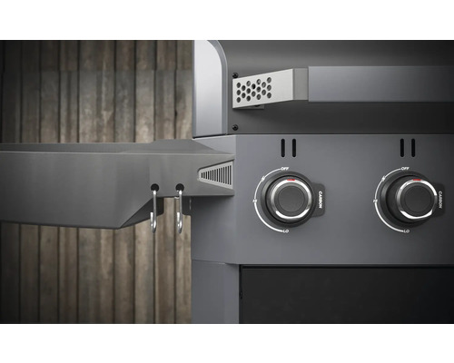 Detailný pohľad na gril na drevené uhlie s otočnými gombíkmi a odkladacím priestorom