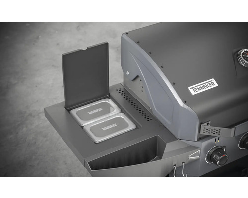 Detailný pohľad na plynový gril s otvoreným ohrievacím roštom a logom Tenneker.