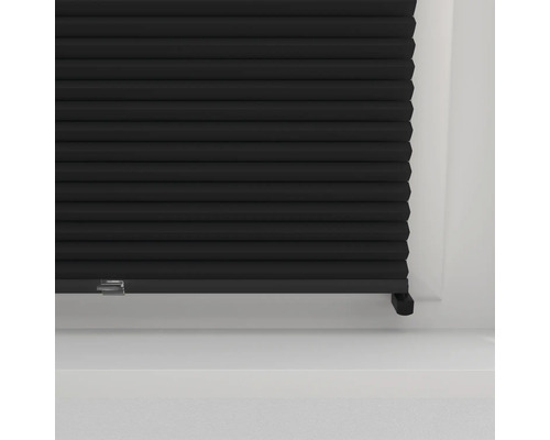 Detail čierneho plisovaného závesu pred oknom