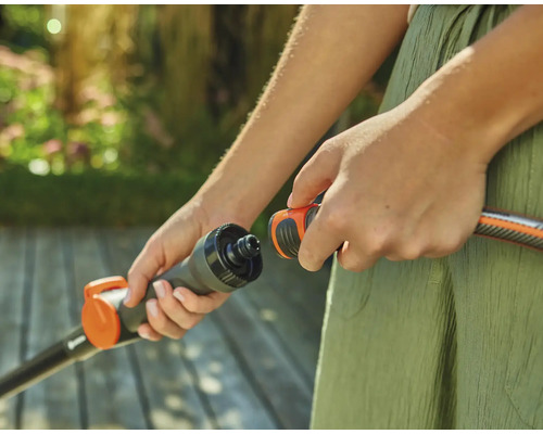 Osoba pripája záhradnú hadicu ku konektoru.