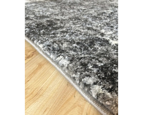 Detail šedého koberca s abstraktným vzorom