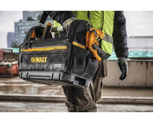 Taška na náradie DeWalt s logom STAK, ktorú nesie osoba.