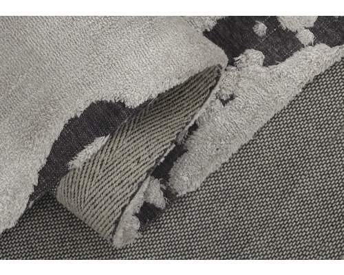 Detailný pohľad na sivočierny koberec s strapcami