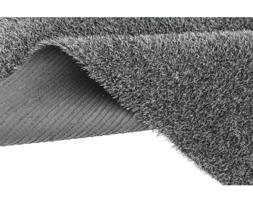 Sivý umelý trávnik so stočeným rohom ukazujúci zadnú stranu