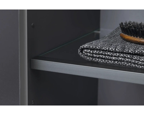 Detail kúpeľňovej skrinky so sklenenou policou, uterákom a kefou