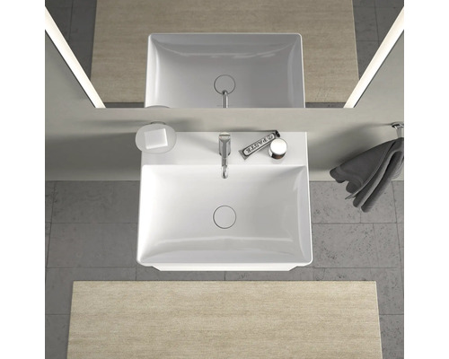 Pohľad zhora na kúpeľňu s umývadlom, mydlom, uterákom a zrkadlom