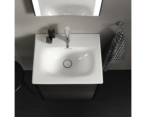 Pohľad zhora na umývadlo v kúpeľni s batériou, uterákom a zrkadlom