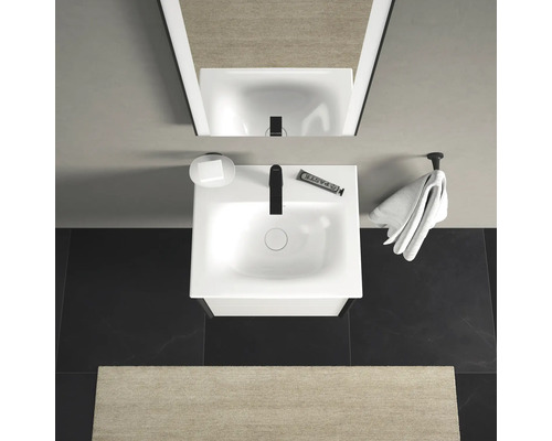 Pohľad zhora na kúpeľňu s umývadlom, mydlom, uterákom a zrkadlom