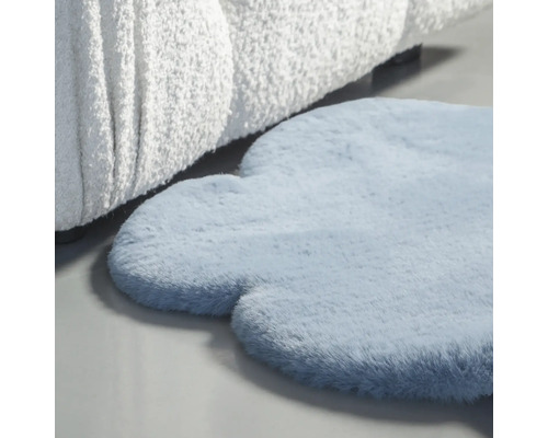 Modrý koberec v tvare oblaku vedľa pohovky.