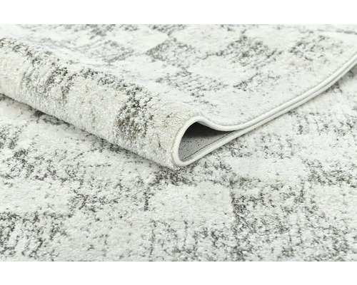 Detail svetlého koberca s abstraktným vzorom