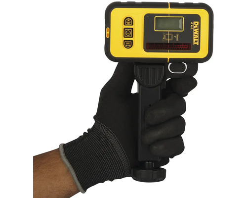 Ruka v rukavici drží žltý a čierny laserový detektor DeWalt