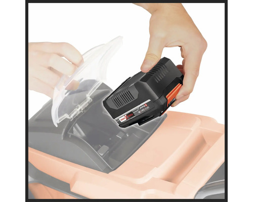 Muž vkladá batériu do kosačky na trávu.