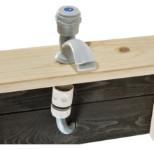 Sivý kohútik s hadicovou prípojkou na drevenom stole