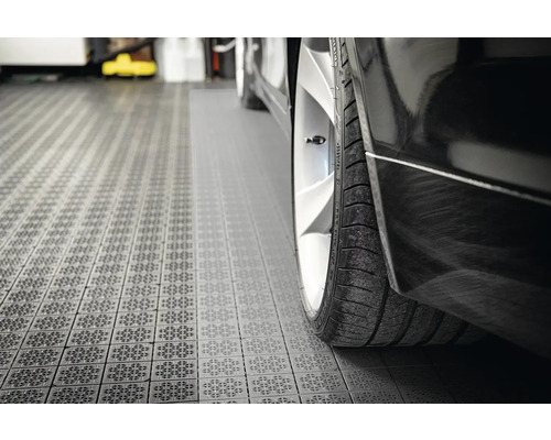 Detailný pohľad na čierne auto na garážových dlaždiciach