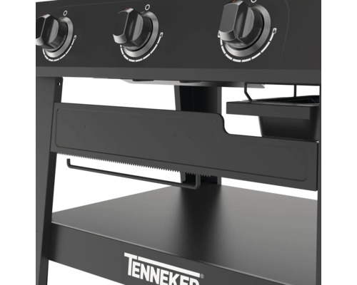 Detailný pohľad na čierny plynový gril s otočnými gombíkmi, držiakom na papierové utierky a odkladacou plochou značky Tenneker.