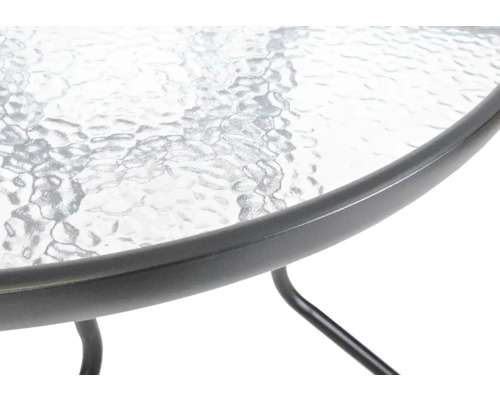 Detail záhradného stola so sklenenou doskou a kovovým rámom