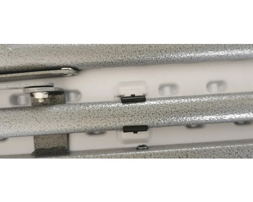 Detailný pohľad na kovový regál so skrutkami a plastovými klipmi