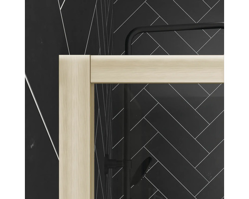 Detailný záber sprchovacieho kúta so svetlými rámami pred stenou so vzorom rybej kosti.