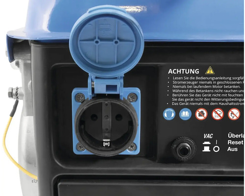 Detailný pohľad na generátor s otvoreným vekom nad zásuvkou a varovaniami.