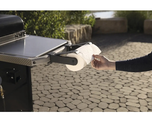 Gril s držiakom na papierové utierky a ruka odvíjajúca papier