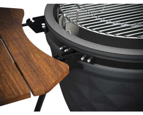 Detailný pohľad na guľatý gril s dreveným stolom