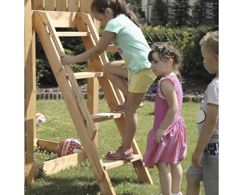 Deti sa hrajú na hracej veži s rebríkom v záhrade.