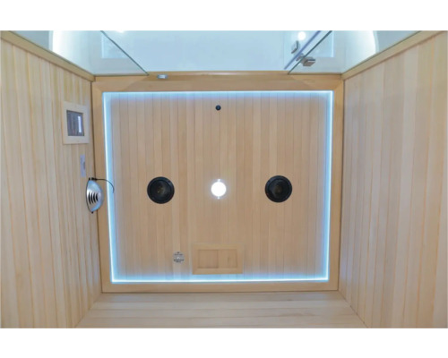 Vnútorný pohľad na saunu s dreveným obkladom, reproduktormi a osvetlením