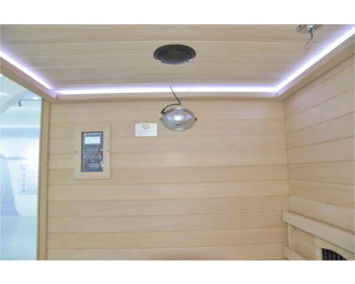 Interiér sauny s dreveným obložením, reproduktorom, svetelnou lištou a ovládacím panelom