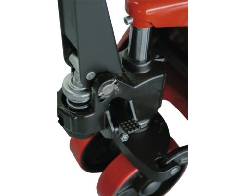 Detailný záber komponentov paletového vozíka, vrátane nožného pedálu, hydraulického valca a koliesok.