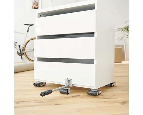 Zdvihák nábytku s bielou komodou na drevenej podlahe