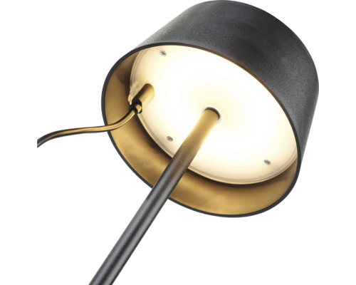 Detailný záber stolnej lampy s okrúhlou základňou a tienidlom.