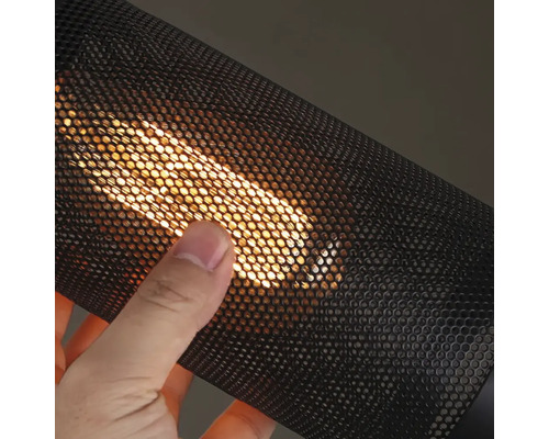 Ruka sa dotýka čiernej lampy s kovovou mriežkou so žiarovkou