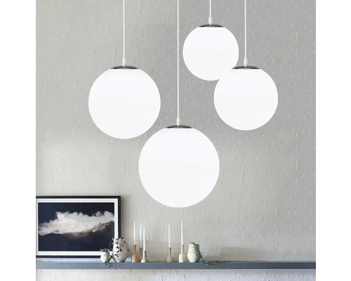 Štyri okrúhle závesné svietidlá s bielymi guľovými tienidlami visia v miestnosti.