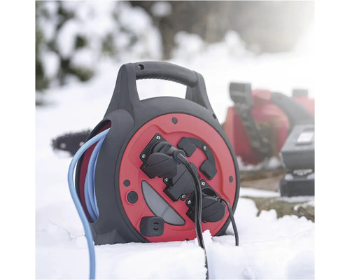 Káblový bubon s modrým káblom a zásuvkami v snehu