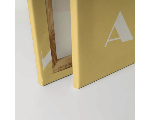 Detail plátna na drevenom slepom ráme s bielou potlačou písmena A