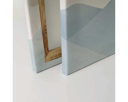 Detailný pohľad na dva obrazy na plátne s abstraktnými motívmi hôr a dreveným rámom