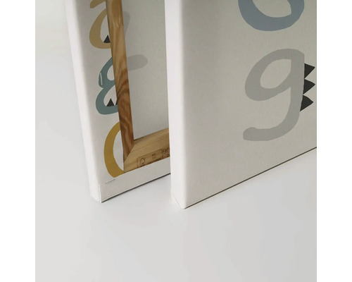 Detailný záber na dva obrazy na plátne s písmenami a dreveným rámom