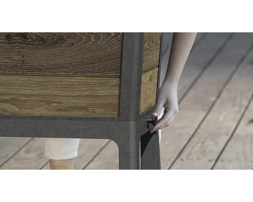 Detailný pohľad na vyvýšený záhon s dreveným obkladom a osobou ovládajúcou otočný gombík na strane