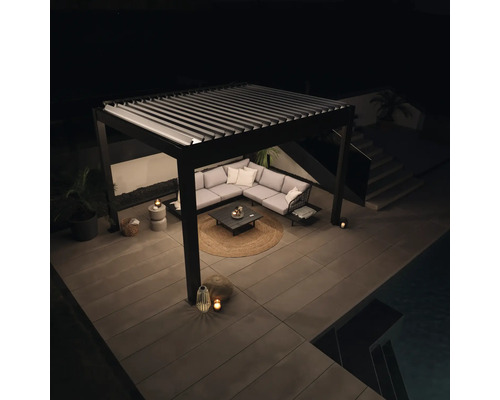 Terasa s lamelovou strechou, rohovou sedačkou a záhradným stolíkom v noci