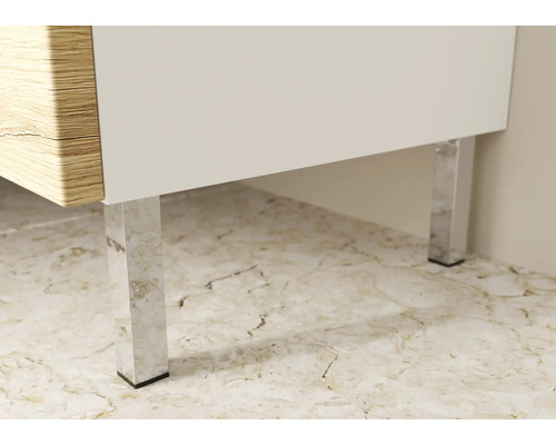 Detail nábytku s dreveným dekorom, bielymi plochami a striebornými nohami