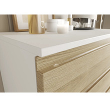 Detail komody so zásuvkami v drevenom dekore a bielom povrchom