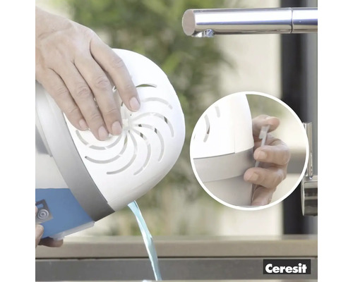 Osoba vyprázdňuje odvlhčovač vzduchu nad umývadlom.