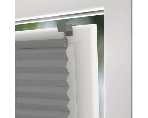 Sivá plisovaná roleta na okne s držiakom na reguláciu svetla