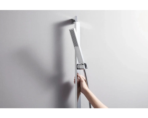 Sprchový stĺp s ručnou sprchou a sprchovou hadicou na stene