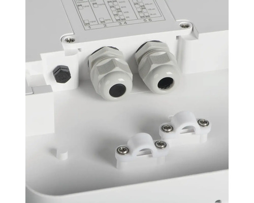 Detail bielej pripojovacej krabice s káblovými priechodkami a káblovými svorkami